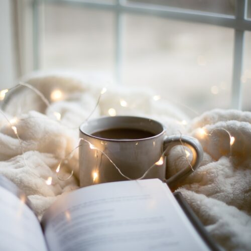 a cup of coffee and a book on a blanket